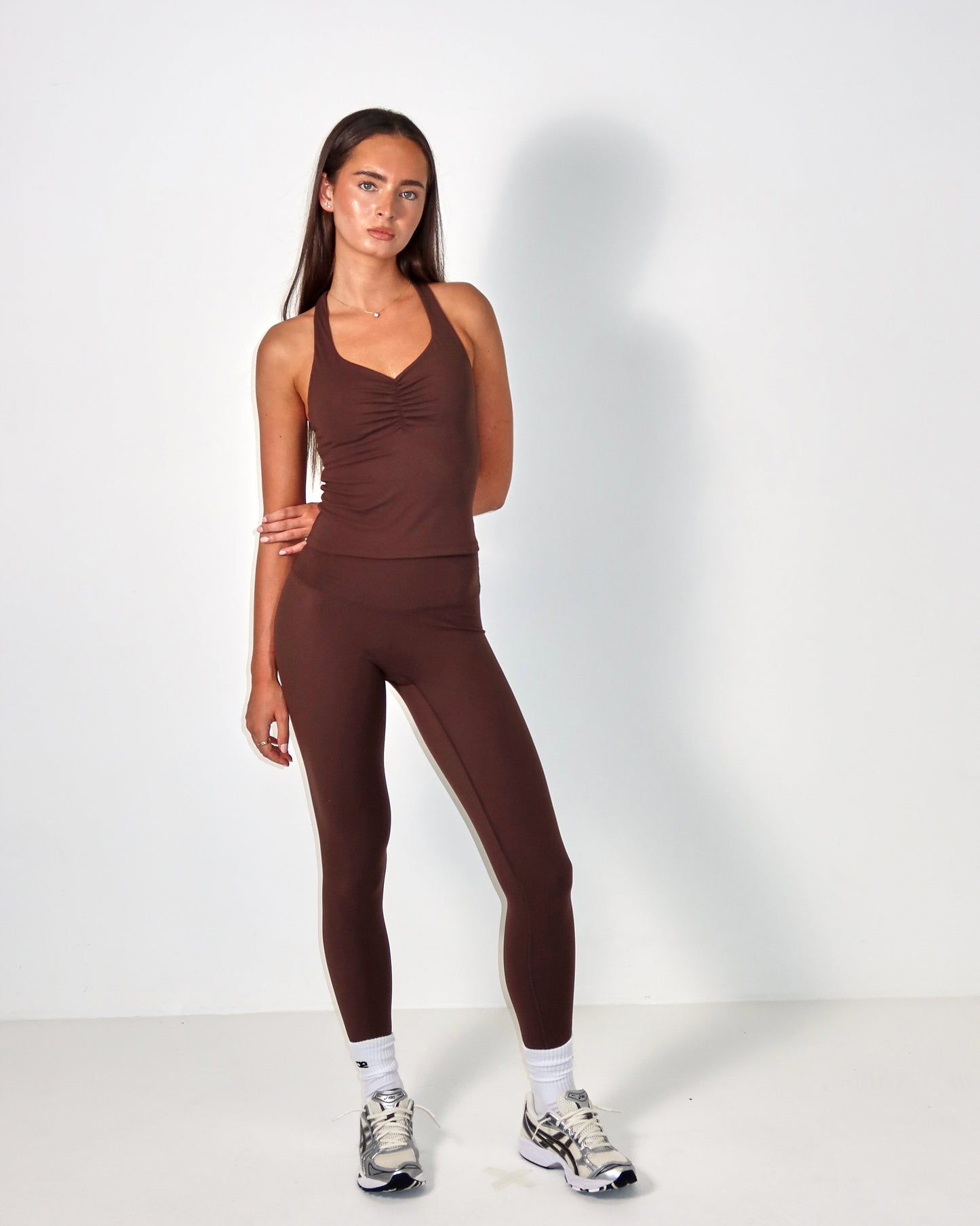 Woman wearing a brown athletic outfit on a white background activewear raae uk