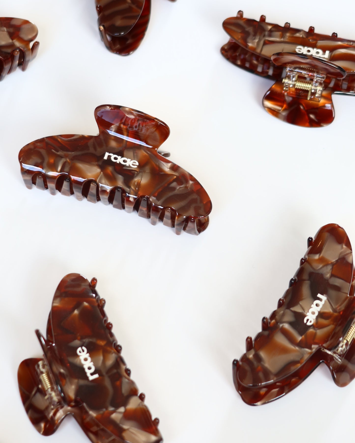 Brown hair clips with 'raae' branding on a white background