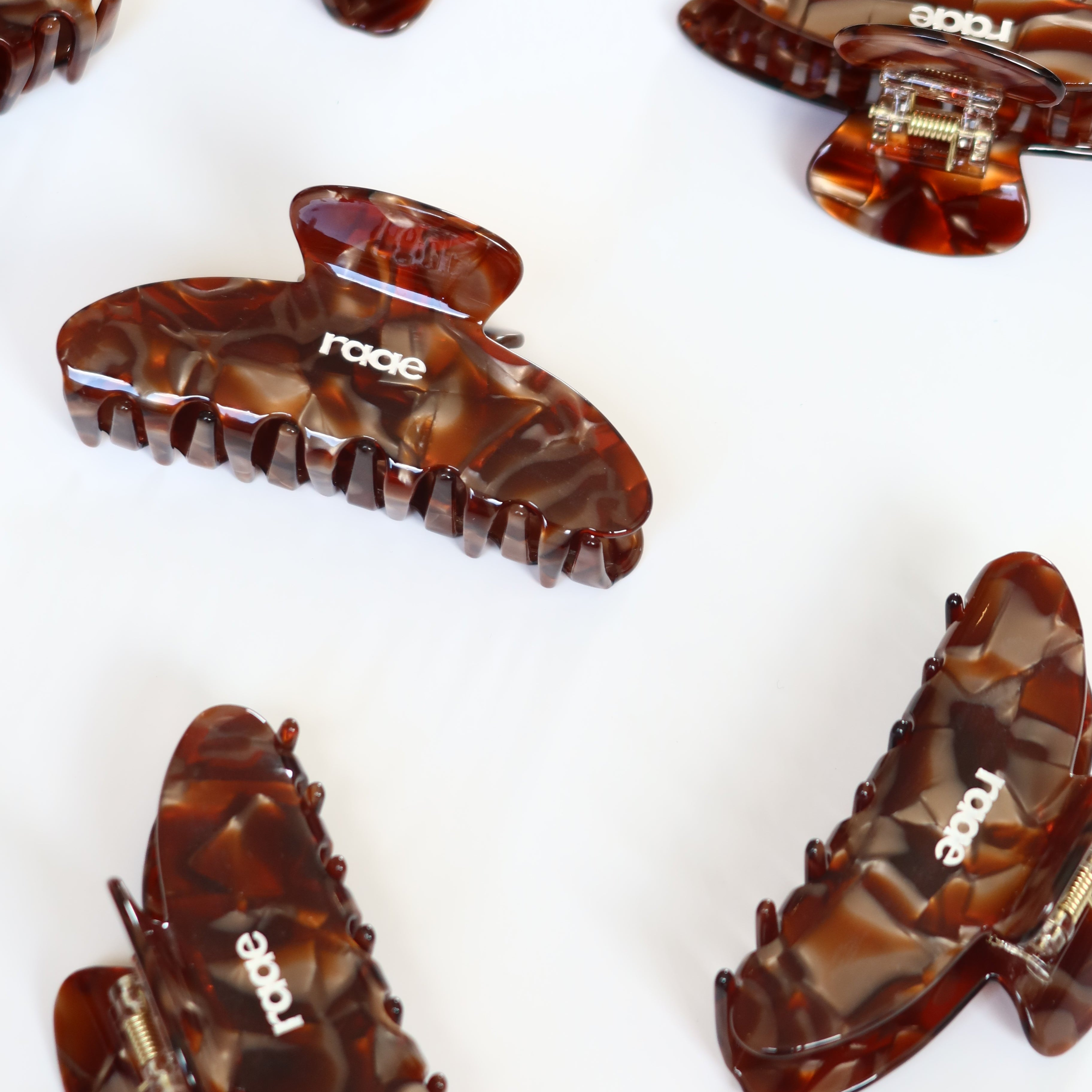 Tortoiseshell hair clips with 'raede' branding on a white background activewear raae uk