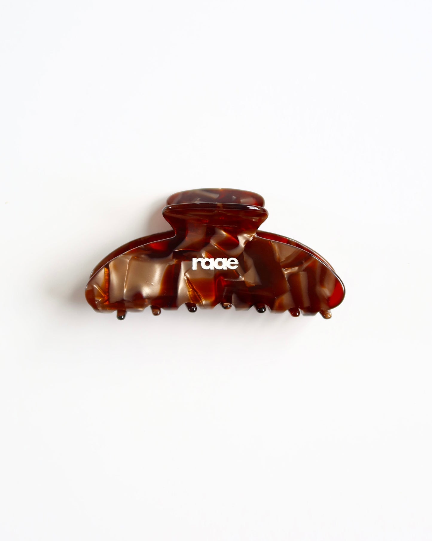 Brown hair clip with 'raae' branding on a white background